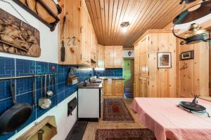 una cocina con armarios de madera y una mesa con mantel rosa. en Chalet am Reschensee, en Resia