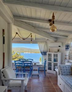 una veranda con sedie blu e vista sull'oceano di House on the beach - Porto Rotondo a Porto Rotondo