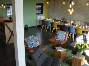 ein Restaurant mit einem langen Tisch und Stühlen sowie einem Tisch und Stühlen in der Unterkunft Classy Holiday Home in Zuidzande with Sauna in Zuidzande
