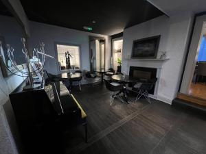 a living room with tables and chairs and a fireplace at manorhaus RUTHIN - manorhaus collection in Ruthin