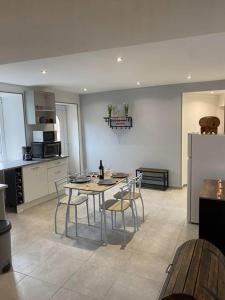 a kitchen with a table and chairs and a refrigerator at Appartement cocooning a ruaux in Plombières-les-Bains