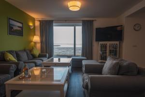 a living room with couches and a view of the ocean at The Saddlers House - best price per bed in Bowmore