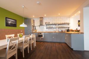 a kitchen with a long table and chairs in a room at The Saddlers House - best price per bed in Bowmore