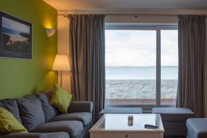 un soggiorno con divano e vista sull'oceano di The Saddlers House - best price per bed a Bowmore