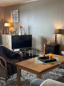 a living room with a coffee table and a flat screen tv at Sjarmerende Bjelbølstølen in Beitostøl