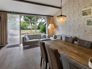 a dining room with a table and a couch at Beautiful holiday home in Horssen at the farm with a garden in Horssen