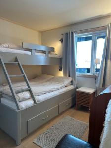 a bedroom with two bunk beds with a window at Sjarmerende Bjelbølstølen in Beitostøl