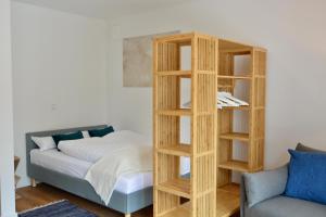 a wooden bookcase next to a bed and a couch at Business Living Oberkochen in Oberkochen