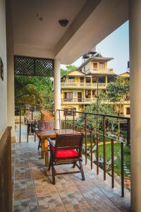- un balcon avec une table et des chaises dans l'établissement Hotel Riverside with Swimming pool, à Sauraha