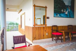 comedor con mesa, sillas y espejo en Hotel Riverside with Swimming pool, en Sauraha