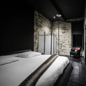 1 dormitorio con 1 cama grande y 1 silla en Une Parenthèse, gîte de charme et spa., en Sainte-Luce-sur-Loire
