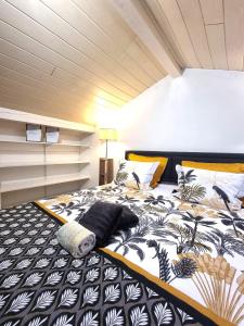 a bedroom with a bed with a black and white comforter at MAISON COSY 7 minutes des frontières in Rosenau