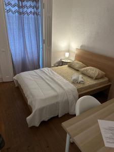 a bedroom with a bed and a table and a window at Palmela Castle Rooms in Palmela