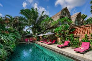 una piscina con tumbonas rosas junto a una casa en De Klumpu Bali Eco Tradi Stay en Bangli