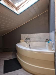 La salle de bains est pourvue d'une baignoire et d'une lucarne. dans l'établissement MAISON COSY 7 minutes des frontières, à Rosenau