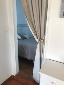 a bedroom with a bed and a curtain at MAMALO in Biscarrosse