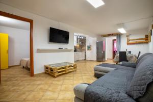 een woonkamer met 2 banken en een flatscreen-tv bij Villa Lina in Castelsardo