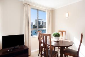 a living room with a dining room table and a window at Harbourside Apartment with Spectacular Pool in Sydney