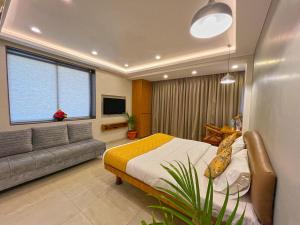 a bedroom with a bed and a couch at Hotel Parklane in Mumbai
