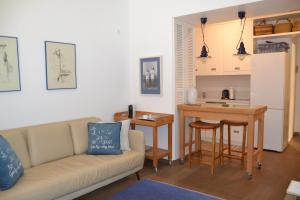 a living room with a couch and a kitchen at Vouliagmeni seaside flat in Athens