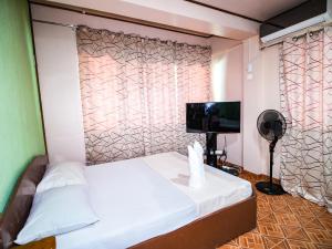 Cette petite chambre comprend un lit et une télévision à écran plat. dans l'établissement Gracias Inn, à Boracay