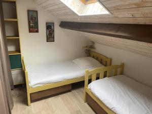 2 łóżka piętrowe w pokoju z sufitem w obiekcie Gite de Belle vue w mieście Semur-en-Brionnais