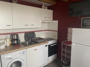 eine Küche mit Spüle und Waschmaschine in der Unterkunft Gite de Belle vue in Semur-en-Brionnais