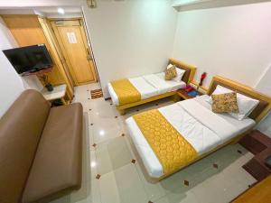 a small room with two beds and a tv at Hotel Parklane in Mumbai