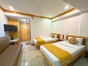 a hotel room with two beds and a tv at Hotel Parklane in Mumbai