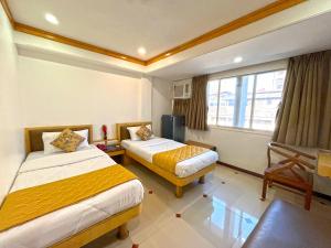 a hotel room with two beds and a window at Hotel Parklane in Mumbai