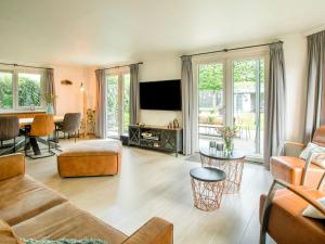 een woonkamer met meubilair en een flatscreen-tv bij Lovely holiday home in Kaatsheuvel with bubble bath in Kaatsheuvel