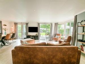 uma sala de estar com um sofá castanho e uma televisão em Lovely holiday home in Kaatsheuvel with bubble bath em Kaatsheuvel