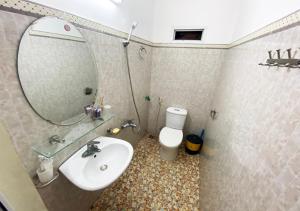 W łazience znajduje się umywalka, lustro i toaleta. w obiekcie Coto Plus Hotel & Restaurant w mieście Quang Ninh