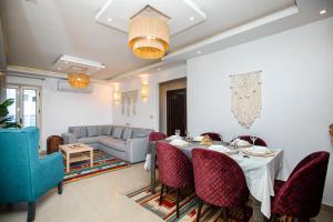 een woonkamer met een tafel en stoelen en een bank bij Dormiery Premium Sea View Apartments in Alexandrië