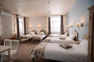 Zimmer mit 4 Betten, Tisch und Stühlen in der Unterkunft Silene Resort & SPA Egles Villa in Silene