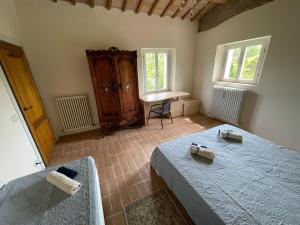 - une chambre avec 2 lits et un bureau dans l'établissement Casale san Valentino, à Tavullia