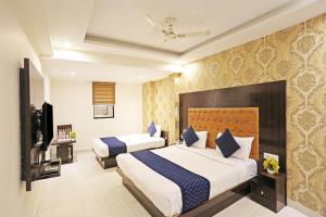 een hotelkamer met 2 bedden en een televisie bij The Iconic Delhi Airport by Midway in New Delhi