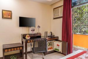 uma sala de estar com uma secretária e uma televisão em Lime Tree 4 BHK Serviced Apartment Greater Kailash -2 em Nova Deli
