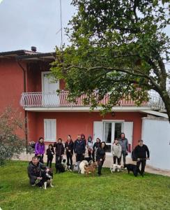 un groupe de personnes debout devant une maison avec des chiens dans l'établissement Pace, Luminosità e Comodità a due passi dal Garda, à Volta Mantovana