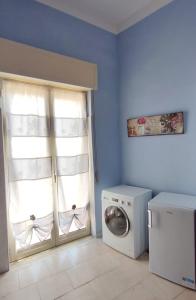 a laundry room with a washing machine and a window at Confy Apartments Pompei in Pompei