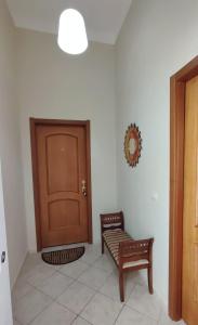 a room with a door and a bench and a chair at Confy Apartments Pompei in Pompei