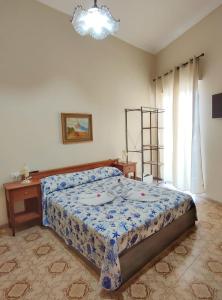a bedroom with a bed and a table and a window at Confy Apartments Pompei in Pompei