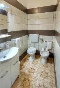 a bathroom with a toilet and a sink at Confy Apartments Pompei in Pompei