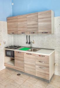 a kitchen with wooden cabinets and a sink at Confy Apartments Pompei in Pompei