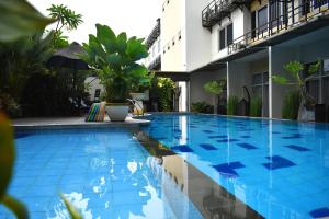 a swimming pool in front of a building at Abadi Hotel Malioboro Yogyakarta in Yogyakarta