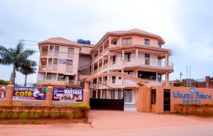 a pink building with a sign in front of it at UBUNTU PALACE HOTEL - RUNATI in Kampala