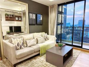 a living room with a couch and a large window at The Astra Condo Changkhlan in Chiang Mai in Chiang Mai