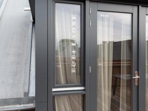szklane drzwi z oknem w budynku w obiekcie Luxury apartment in Renesse with infrared sauna w mieście Renesse