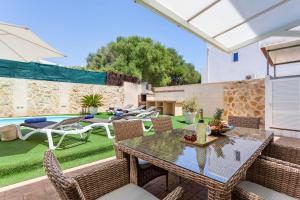 a patio with a table and chairs and a pool at Casa Nikydan with privat pool in Cala d´Or