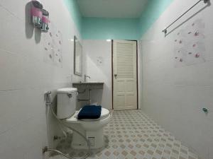 Baño con aseo y toalla azul en NUN GUEST HOUSE, en Ban Bo Han